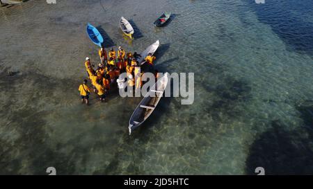 Lembongan, Bali/6. Mai 2022: Menschen in orangefarbener Kleidung erforschen das Algengebiet auf der Insel Lembongan, Bali. Sie sammeln sich unter den EM Stockfoto