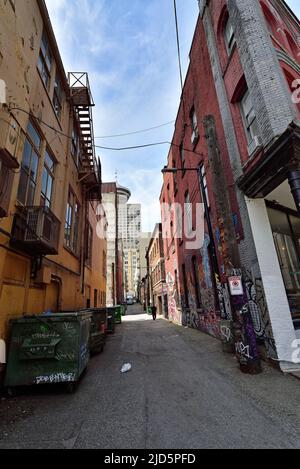 VANCOUVER, BRITISH COLUMBIA, KANADA, 31. MAI 2019: Eine schmale Gasse zwischen farbigen alten Backsteingebäuden und Müllcontainern am Abend im Van Stockfoto