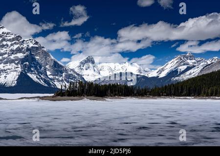 Der obere Kananaskis Lake ist an einem Frühlingstag in den kanadischen Rocky Mountains in der Nähe von Banff mit schmelzendem gefrorenem Eis bedeckt. Stockfoto