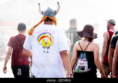 18. Juni 2022, Niedersachsen, Scheeßel: Festspielbesucher kühlen sich bei hohen Temperaturen beim „The Turmean Festival“ unter künstlichem Regen ab. Das Open-Air-Festival mit rund 78.000 Besuchern pro Tag findet vom 17. Bis 19. Juni statt. Foto: Hauke-Christian Dittrich/dpa Stockfoto