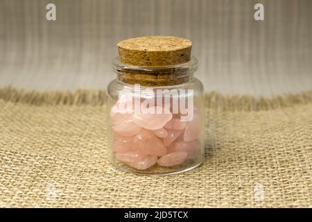 Mehrere Stücke von poliertem rosa Quarz auf glitterrosa Hintergrund. Minimalfarben Standbilder Draufsicht Stockfoto