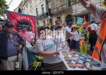 London, Großbritannien. 18 Juni 2022. Ein neu-Mitglied hält vor dem marsch ein Kind fest. Viele Tausende marschierten in einem von der TUC organisierten marsch durch London, um zu sagen: "Genug ist genug" - wir brauchen Maßnahmen bei den Lebenshaltungskosten, für höhere Löhne und einen New Deal für arbeitende Menschen, einschließlich eines Mindestlohns von £15. Sie fordern ein seit langem versprochenes Arbeitsgesetz, um die Dinge gerechter zu machen, und eine Regierung, die die arbeitenden Menschen unterstützt und die Tarifverhandlungen fördert. Peter Marshall / Alamy Live News Stockfoto