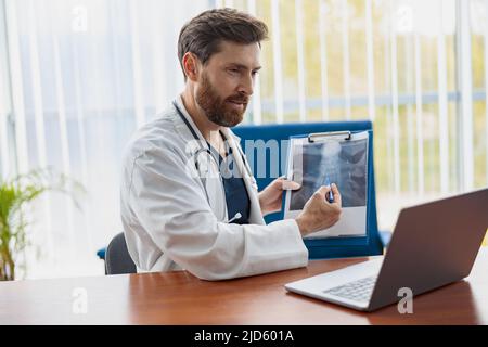 Der Therapeut führt Videokonsultationen durch, kommuniziert mit dem Patienten über einen Anruf per Laptop Stockfoto