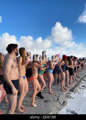 Stanley, Großbritannien. 18.. Juni 2022. Teilnehmer des traditionellen Winterschwimmens stehen zur Verfügung. Dutzende trotzten dem eiskalten Wetter auf den Falklandinseln und sprangen zum Winterschwimmen in den Südatlantik. Quelle: Benedikt von Imhoff/dpa/Alamy Live News Stockfoto