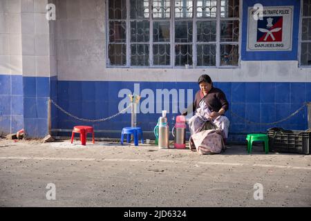 Kurseong, Westbengalen, Indien. 15. April 2022. Eine Dame, die Tee vor der Polizei verkauft.Kurseong ist eine malerische Schönheit, eine Hügelstadt in Westbengalen im östlichen Himalaya. Es ist eine Stadt und eine Gemeinde in Darjeeling, Westbengalen. Kurseong liegt auf einer Höhe von 1.482,55 Metern und ist nur 32 Kilometer von Darjeeling entfernt. Die Stadt wurde ursprünglich Karsan Rup genannt, was das „Land der weißen Orchidee“ bedeutet. Es ist der ideale Ort, um stressfreie Tage zu verbringen, während Sie vom östlichen Himalaya und Frieden umgeben sind. Hügel und Gipfel wie Mt Kanchenzöna, Dow Hill, St Mary's Hill und Stockfoto