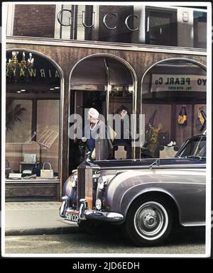 Eine elegant gekleidete Dame mit Turban, Perlen und Handschuhen verlässt den Gucci-Laden in der Bond Street, um in ihren wartenden Rolls Royce zu treten, der vor der Colorized-Version von : 10113819 geparkt ist Datum: 1960s Stockfoto