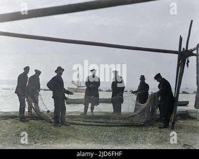 Eine Gruppe von Fischern am Strand von Margate, Kent, England, sortiert ihre Fischernetze. Kolorierte Version von : 10165182 Datum: Anfang 1930s Stockfoto