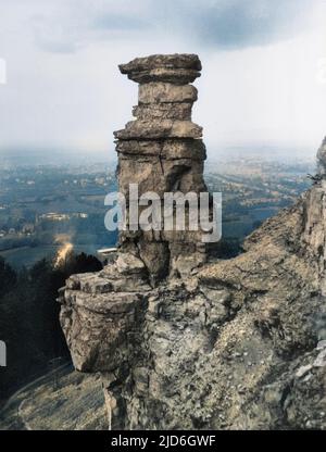 The Devil's Chimney', eine stipintive natürliche Felsformation auf dem Leckhampton Hill, mit Blick auf die Straße zwischen Cheltenham und Birdlip, Gloucestershire, England. Kolorierte Version von : 10184373 Datum: Ende 1930s Stockfoto