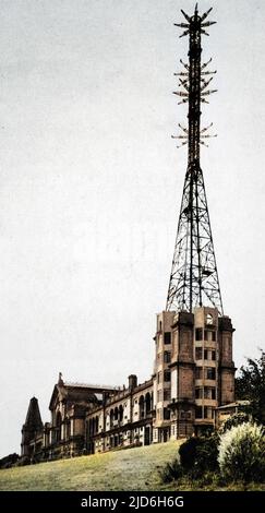 Alexandra Palace als die Heimat des B.B.C Fernsehdienstes, der den Mast zeigt und Antennen für Sicht und Ton sendet. Spezielle Tests des Empfangs des B.B.C vom Alexandra Palast des synchronisierten Fernsehens und der Rede wurden in Olympia durch ein Komitee der Radio-Hersteller-Vereinigung gehalten. An abwechselnden Tagen wurden Übertragungen von Alexandra Palace von Baird und Marconi E.M.I Systemen gegeben. 1935 experimentierte die B.B.C mit dem Fernsehsystem von John Logie Baird und dem E.M.I-System von Marconi. Die E.M.I folgte Baird's 1937. Kolorierte Version von: 10216489 Datum: 1936 Stockfoto