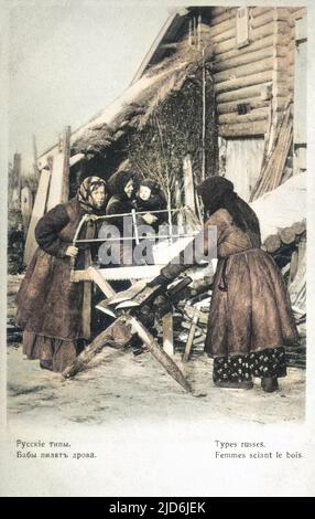 Russische Bauernfrauen (warm eingewickelt gegen die bittere Winterkälte) sägen Holz vor ihrem Haus. Kolorierte Version von: 10638426 Datum: 1904 Stockfoto