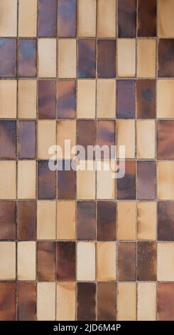 Wand aus verwitterten und schmutzigen braunen und beigen Fliesen oder Blöcken. Vorderansicht. Hochauflösender texturierter Hintergrund im Vollformat. Speicherplatz kopieren. Stockfoto