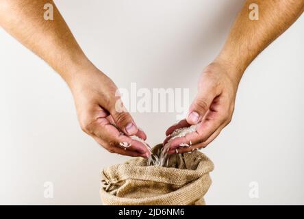 Hände halten Reis, Beutel mit Reis Stockfoto