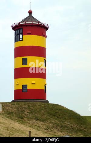 Süßer deutscher Leuchtturm in rot und gelb. Er wurde 1891 gebaut und ist 11 Meter hoch. Es ist bekannt als der Leuchtturm von Pilsum Stockfoto