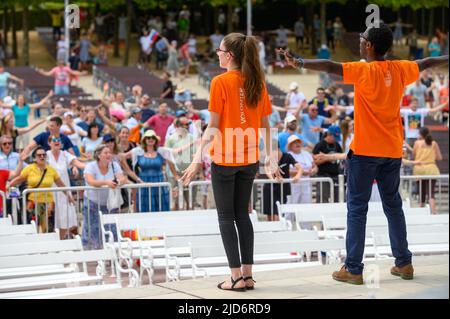 Freiwillige zeigen Hand- und Körperbewegungen für christliche Lieder beim Mladifest 2021, dem Jugendfestival in Medjugorje. Stockfoto