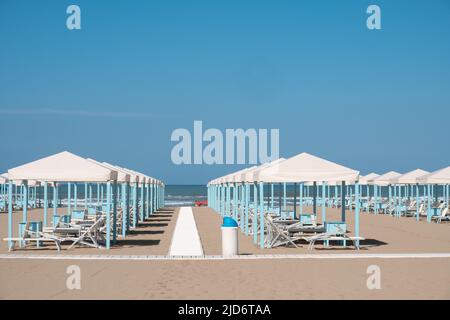 Blau-weiße Strandhütten in Viareggio, Italien, standen für die Strandbesucher bereit. Stockfoto
