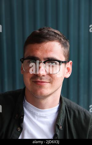 Mann mit Brille. Glücklicher lächelnder kluger Mann. Portrait von schönen lächelnd stilvolle Hipster lambersexual Modell. Männlich auf dem modernen Hintergrund Stockfoto