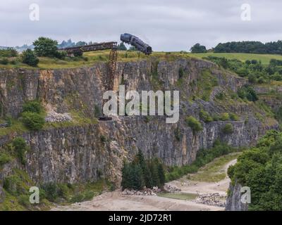 ***Video verfügbar*** Mission: Impossible 7 Lokomotivzug-Crashszene in Stoney Middleton, Derbyshire. Der nachgebaute Dampfzug der British Railway Britannia wird für die letzte Crashszene in Tom Cruise's neuestem Blockbuster-Film von der Klippe getrieben. Die Lokomotive fliegt in spektakulärem Stil durch die Luft, bevor sie in den Steinbruch darunter stürzt. Die Szene wurde von zwei Hubschraubern und vielen entfernten Kameras gefilmt. Tom Cruise kam kurz vor der letzten Absturzszene in seinem Personalhubschrauber an, er flog um den Film, bevor er auf den Feldern in der Nähe der Eisenbahnstrecke über dem Steinbruch landete. Der Dampfstoß tr Stockfoto