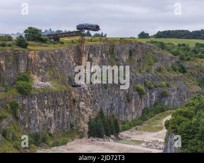 ***Video verfügbar*** Mission: Impossible 7 Lokomotivzug-Crashszene in Stoney Middleton, Derbyshire. Der nachgebaute Dampfzug der British Railway Britannia wird für die letzte Crashszene in Tom Cruise's neuestem Blockbuster-Film von der Klippe getrieben. Die Lokomotive fliegt in spektakulärem Stil durch die Luft, bevor sie in den Steinbruch darunter stürzt. Die Szene wurde von zwei Hubschraubern und vielen entfernten Kameras gefilmt. Tom Cruise kam kurz vor der letzten Absturzszene in seinem Personalhubschrauber an, er flog um den Film, bevor er auf den Feldern in der Nähe der Eisenbahnstrecke über dem Steinbruch landete. Der Dampfstoß tr Stockfoto