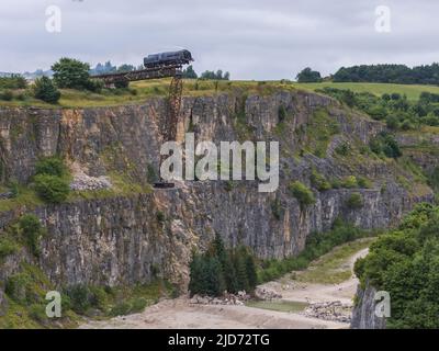 ***Video verfügbar*** Mission: Impossible 7 Lokomotivzug-Crashszene in Stoney Middleton, Derbyshire. Der nachgebaute Dampfzug der British Railway Britannia wird für die letzte Crashszene in Tom Cruise's neuestem Blockbuster-Film von der Klippe getrieben. Die Lokomotive fliegt in spektakulärem Stil durch die Luft, bevor sie in den Steinbruch darunter stürzt. Die Szene wurde von zwei Hubschraubern und vielen entfernten Kameras gefilmt. Tom Cruise kam kurz vor der letzten Absturzszene in seinem Personalhubschrauber an, er flog um den Film, bevor er auf den Feldern in der Nähe der Eisenbahnstrecke über dem Steinbruch landete. Der Dampfstoß tr Stockfoto