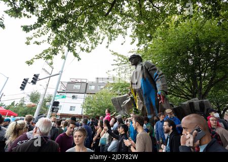 Seattle, Washington, USA. 18.. Juni 2022. Bei der Fremont Solstice Parade drängen Zuschauer die Wahrzeichen-Statue von Wladimir Lenin. Die ikonische, jährliche Parade kehrte nach einer dreijährigen Pause aufgrund der Coronavirus-Pandemie zurück. Quelle: Paul Christian Gordon/Alamy Live News Stockfoto