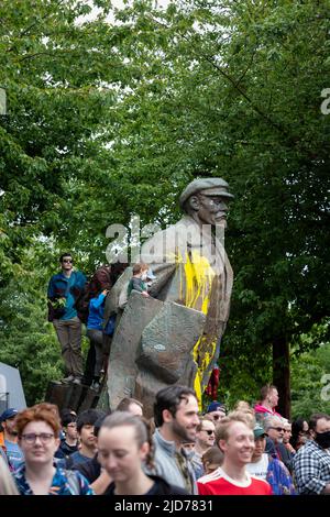 Seattle, Washington, USA. 18.. Juni 2022. Bei der Fremont Solstice Parade drängen Zuschauer die Wahrzeichen-Statue von Wladimir Lenin. Die ikonische, jährliche Parade kehrte nach einer dreijährigen Pause aufgrund der Coronavirus-Pandemie zurück. Quelle: Paul Christian Gordon/Alamy Live News Stockfoto