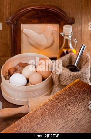 Küche Stillleben mit Eiern. Kochen Sie zu Hause. Einfache Produkte - Mehl und Eier auf Holztisch Stockfoto