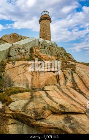 Leuchtturm auf einem felsigen Hügel mit blauem Himmel und Wolken. Galicien Spanien. Stockfoto