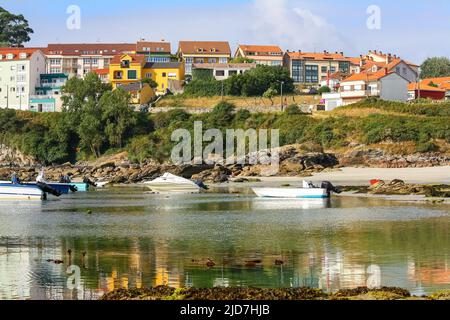 Bunte Häuser auf der Spitze der Klippe am Meer und kleine Boote im Wasser. Stockfoto