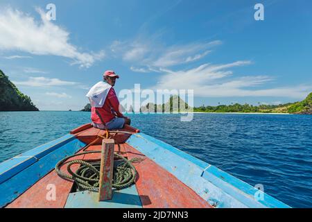 Bootstour Kapitän vor der Küste von Siau Island mit wunderschönem weißen Sand Masare Island dahinter. Masare, Siau, Sangihe-Archipel, Nord-Sulawesi, Indonesien Stockfoto