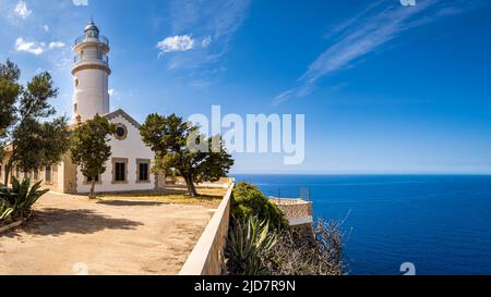 Außenansicht über den Vorplatz eines Mallorcas Leuchtturms namens Far del Cap Gros im Dorf Port de Soller mit Pinien im Vordergrund. Stockfoto