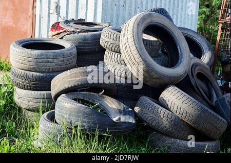 Ein Haufen alter Autoreifen liegt im Gras Stockfoto
