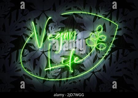 Vegan Life Neon Zeichen auf einer dunklen Holzwand mit Blumen Stockfoto