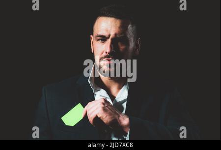 Geschäftsmann mit Kreditkarte. Geschäftsmann in schwarzem Anzug legen oder nehmen Sie Kreditkarte in der Tasche, Nahaufnahme. Stockfoto