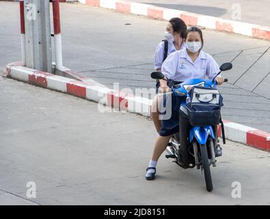 SAMUT PRAKAN, THAILAND, JUNI 10 2022, zwei Mädchen in Schuluniformen fahren auf einem Motorrad Stockfoto