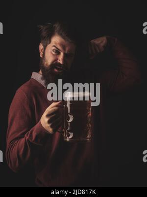 Mann mit Bierkrug. Bärtiger Mann trinkt Lagerbier. Konzept des Craft Beer. Bier in Großbritannien. Stockfoto