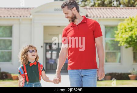 Vater unterstützt und motiviert Sohn. Kind geht zur Grundschule. Zurück in die Schule und glückliche Zeit. Stockfoto