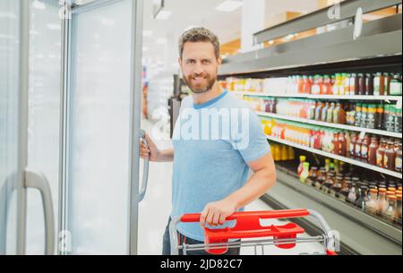 Kunde Kunde Kunde mit Einkäufen. Mann mit Einkaufswagen in einem Lebensmittelgeschäft. Stockfoto