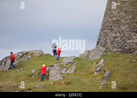 Menschen, die im April in Dun Carloway auf der Isle of Lewis um den Broch herumlaufen und die Gegend erkunden, Äußere Hebriden, Schottland, Vereinigtes Königreich Stockfoto