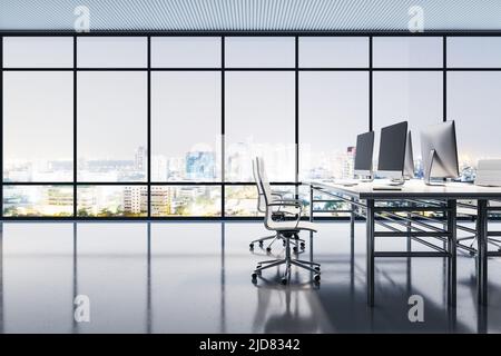 Seitenansicht auf Coworking-Büroarbeitsplätze mit modernen Computern auf Tischen, glänzendem Boden und Blick auf die Stadt der Nacht aus dem großen Fenster. 3D Rendern Stockfoto