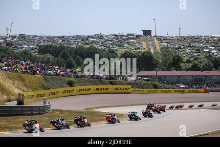 Hohenstein Ernstthal, Deutschland. 19.. Juni 2022. Motorsport/Motorrad, großer Preis von Deutschland, Moto3 Rennen auf dem Sachsenring. Das Feld der Fahrer tritt das Omega, im Hintergrund der Ankerberg. Quelle: Jan Woitas/dpa/Alamy Live News Stockfoto