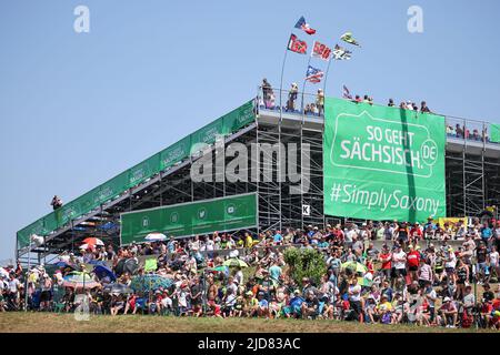 Hohenstein Ernstthal, Deutschland. 19.. Juni 2022. Motorsport/Motorrad, großer Preis von Deutschland, Moto3 Rennen auf dem Sachsenring. Zahlreiche Zuschauer sitzen auf und vor den Tribünen. Quelle: Jan Woitas/dpa/Alamy Live News Stockfoto