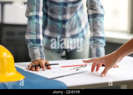Architekt diskutiert Projekt mit Kollegen anhand von Bauplänen Stockfoto