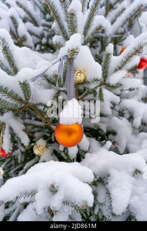 Weihnachten Spielzeug Kugeln auf dem Weihnachtsbaum. Schnee auf einem Ast. Straßendekoration im Winter. Winterhintergrund. Stockfoto
