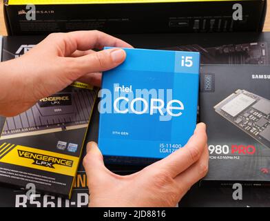 Tambow, Russische Föderation - 07. April 2022 Eine Frau hält Box mit einer Intel Core i5 11400 CPU über andere Boxen mit brandneuen Komponenten in der Hand Stockfoto