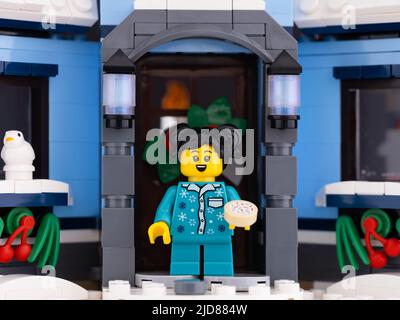 Tambow, Russische Föderation - 26. Mai 2022 Eine Lego-Minifigur, die vor ihrem Haus steht und einen Keks hält. Weihnachtszeit. Stockfoto