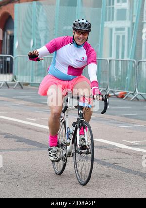 Brighton UK 19. June 2022 - Ein Radfahrer in einem Tutu, der an einem viel kühleren Tag als vor kurzem an der Fahrradtour von London nach Brighton teilnimmt : Credit Simon Dack / Alamy Live News Stockfoto