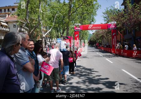 Borgo Val di Taro, Parma, Italien - Mai 2022: Menschen mit rosa Fahnen mit dem Logo des Giro d'Italia stehen an der Straße und warten auf das Hauptfeld der Radfahrer Stockfoto