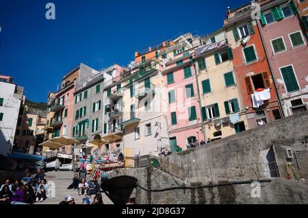 Riomaggiore, Ligurien, Italien - April, 2022: Traditionelle mediterrane italienische Wohnhäuser mit verwitterten bunten Fassaden Stockfoto