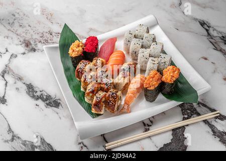 Set aus verschiedenen bunten Maki Sushi-Rollen, Nigiri und Gunkan mit Tiger Shrimps, tomago, Lachs, Thunfisch, chuka-Salat, Fliegender Fischkaviar, Thunfisch und Grün Stockfoto