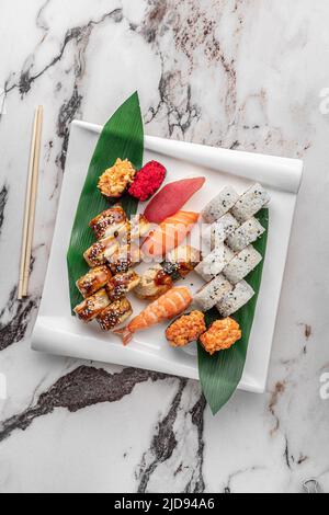 Set aus verschiedenen bunten Maki Sushi-Rollen, Nigiri und Gunkan mit Tiger Shrimps, tomago, Lachs, Thunfisch, chuka-Salat, Fliegender Fischkaviar, Thunfisch und Grün Stockfoto